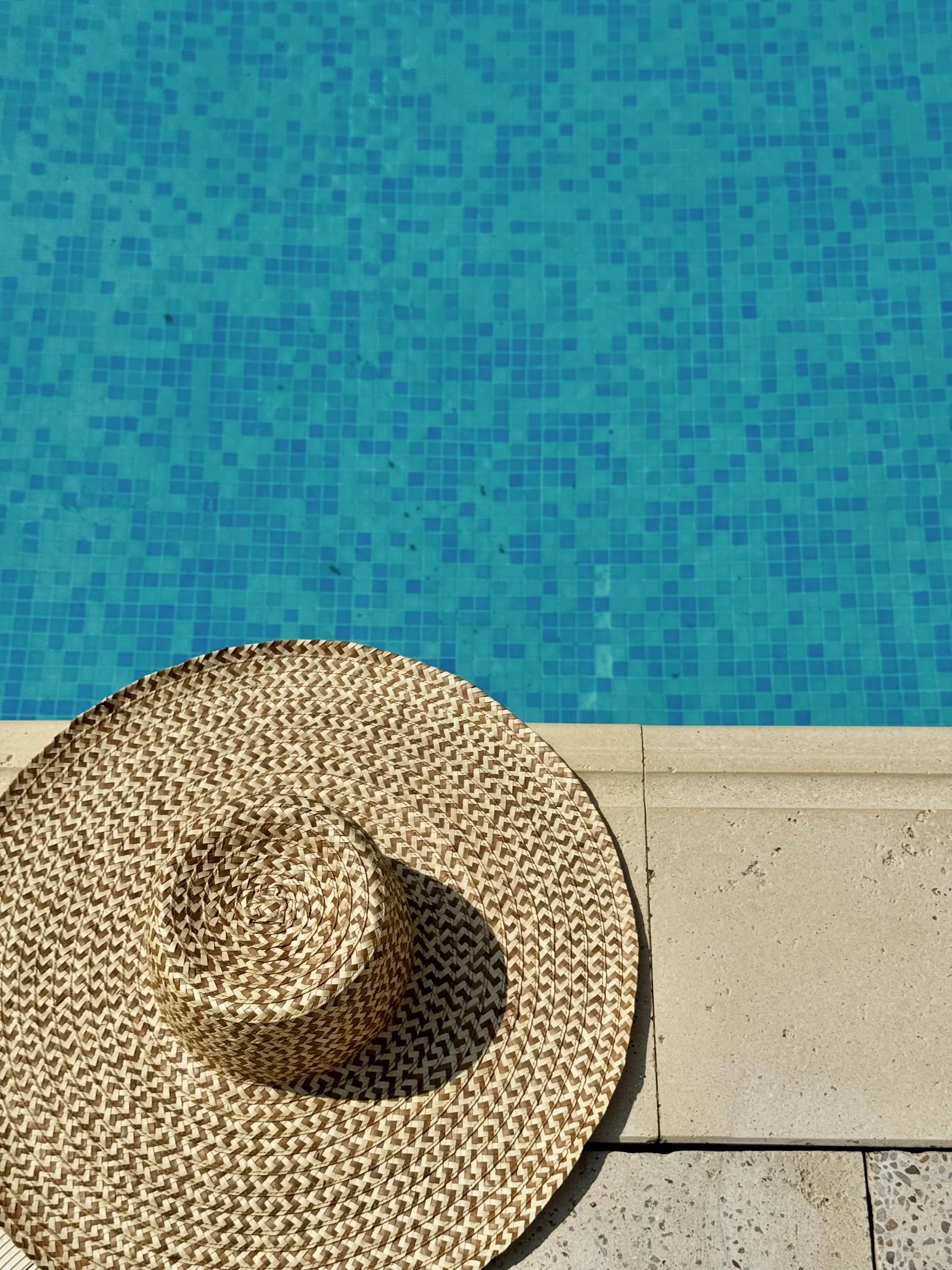 Pălărie de paie pe marginea piscinei